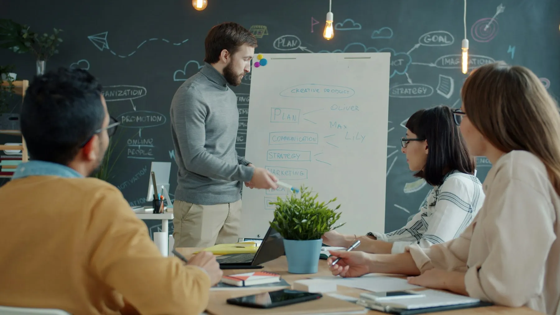 Team member presenting strategy on a whiteboard during a focused planning session
