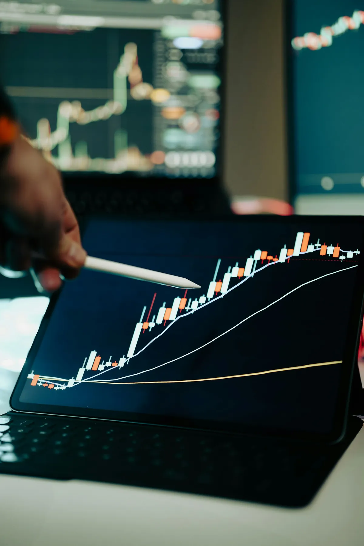 Person pointing at an upward-trending growth chart on a tablet screen